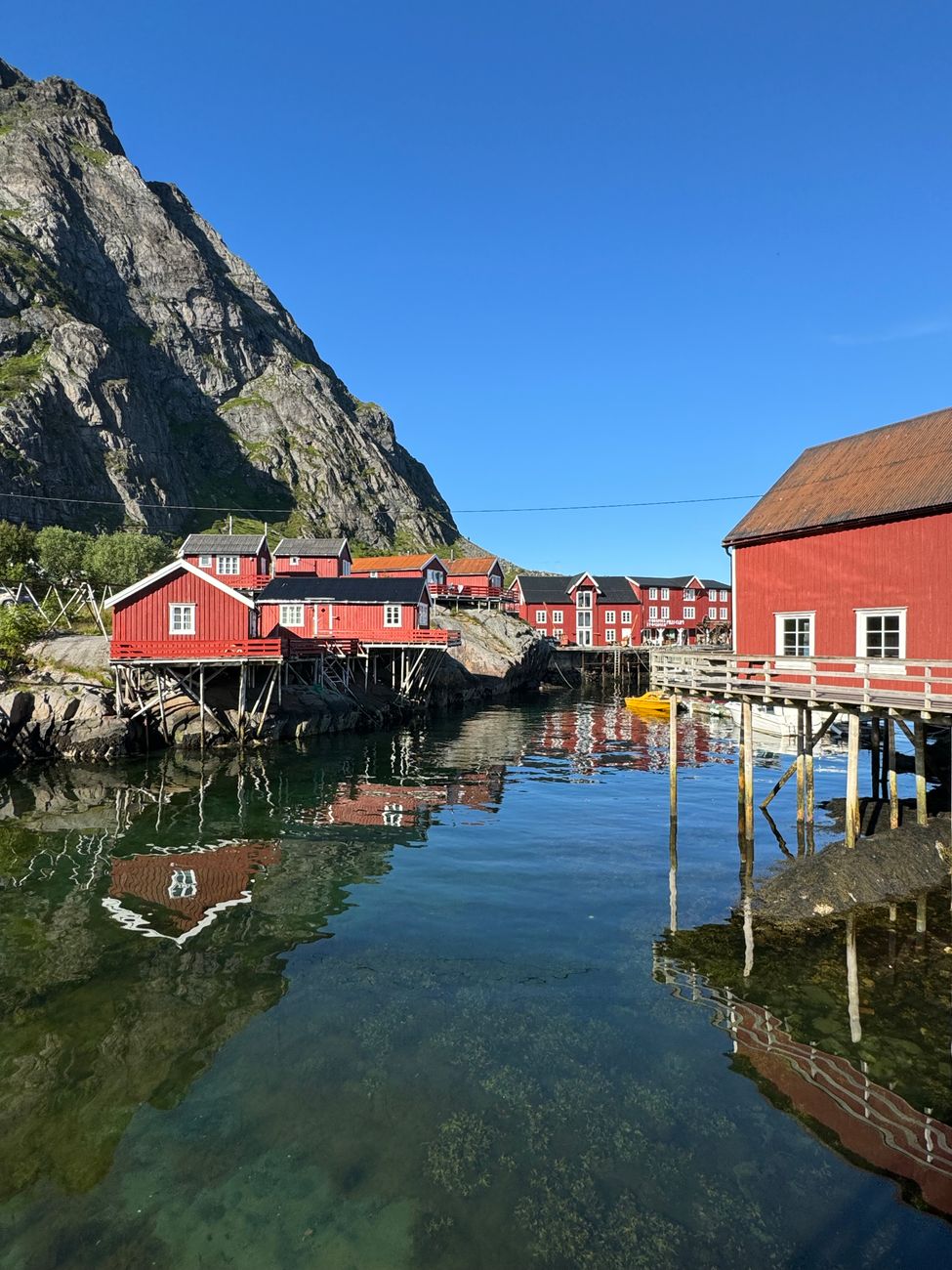 Stilted crimson fishing houses in northern Norway against mountain backdrop